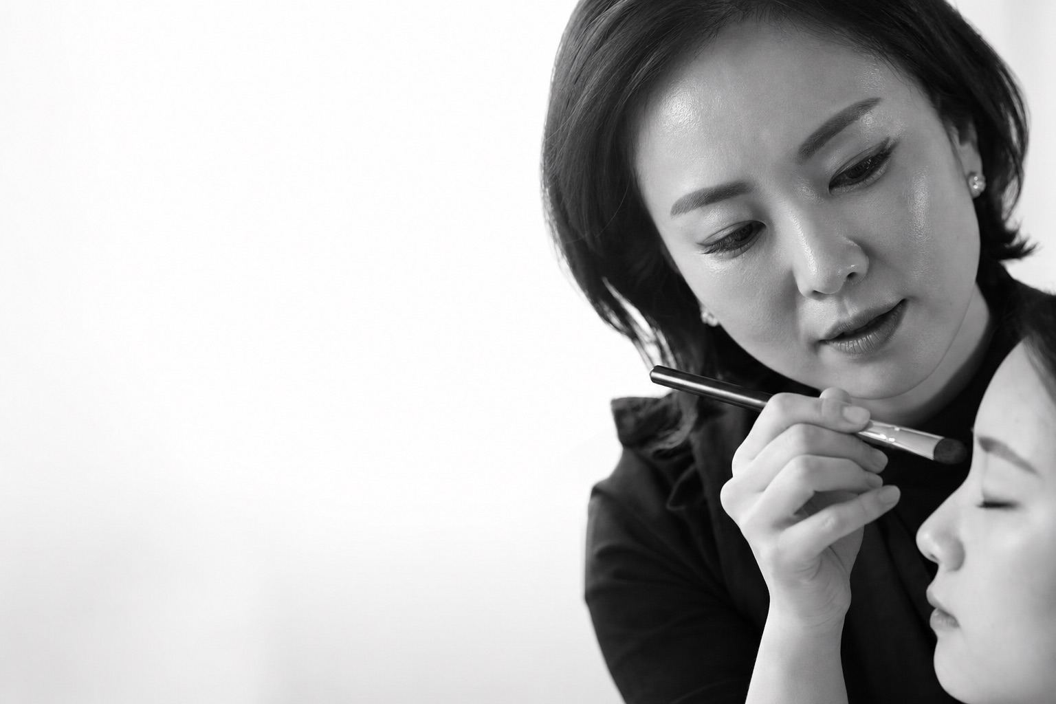 시안 1 에디토리얼 아카데미 키비주얼 — 흑백 강사 메이크업 브러시 시연 클로즈업